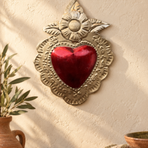 Handmade red and gold tin sacred heart wall decor in a warm MexRoots-style home